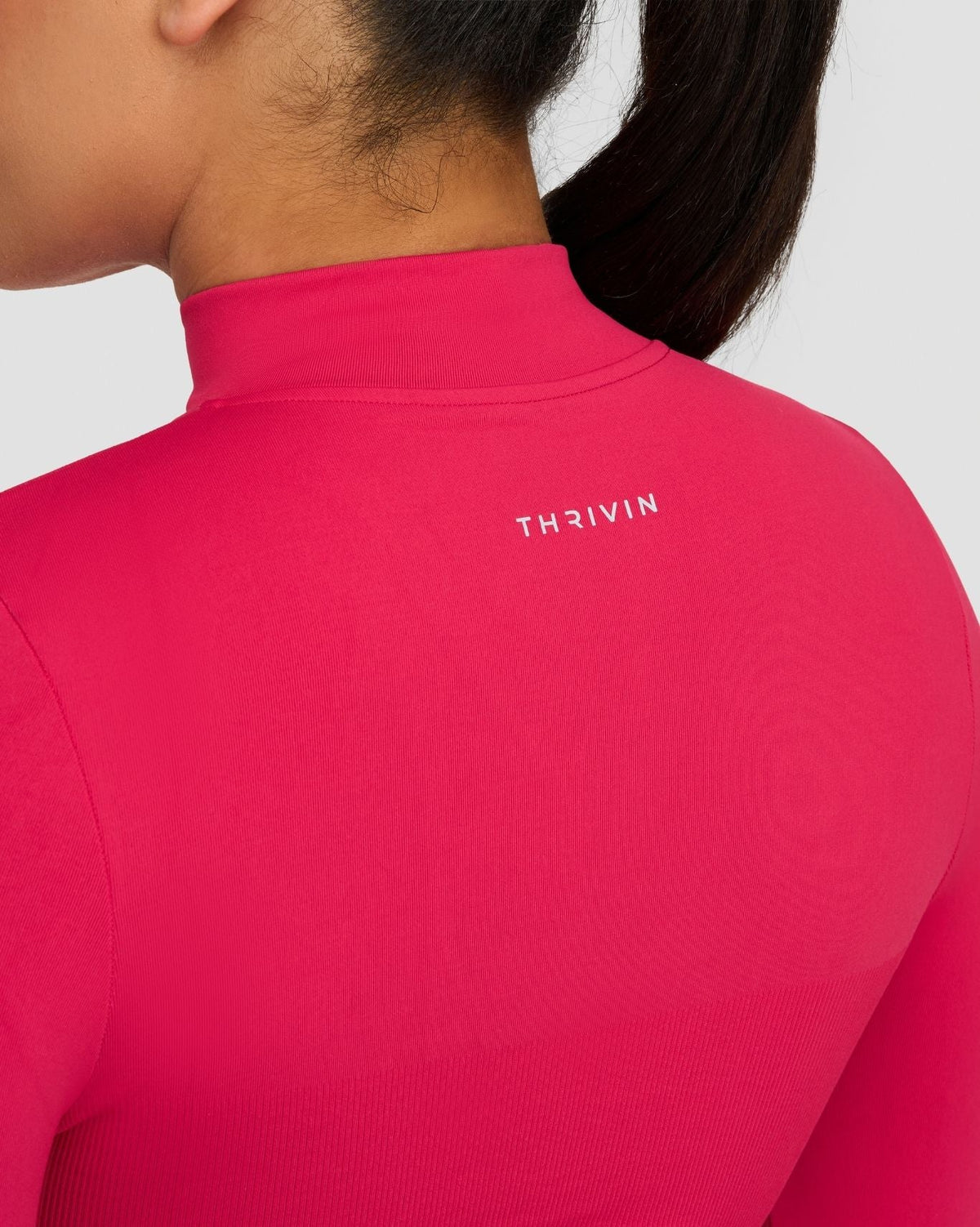 Elevate Compression Long Sleeve Jacket in Strawberry, back neck close-up of THRIVIN logo