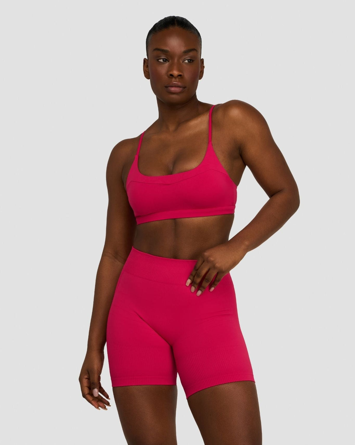 Elevate Sculpting Seamless Scoop Neck Bra in Strawberry, front view, hand on hip, styled with matching shorts