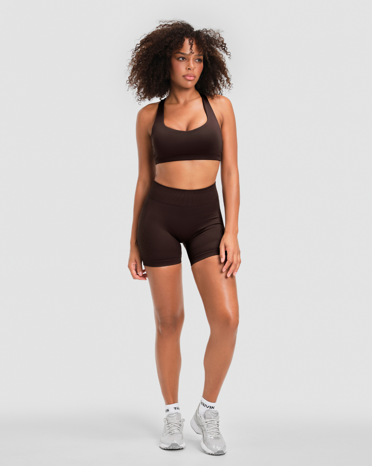 Elevate Sculpting Mid Waist Scrunch Shorter Shorts in Coffee Brown, full-length front view styled with a matching sports bra