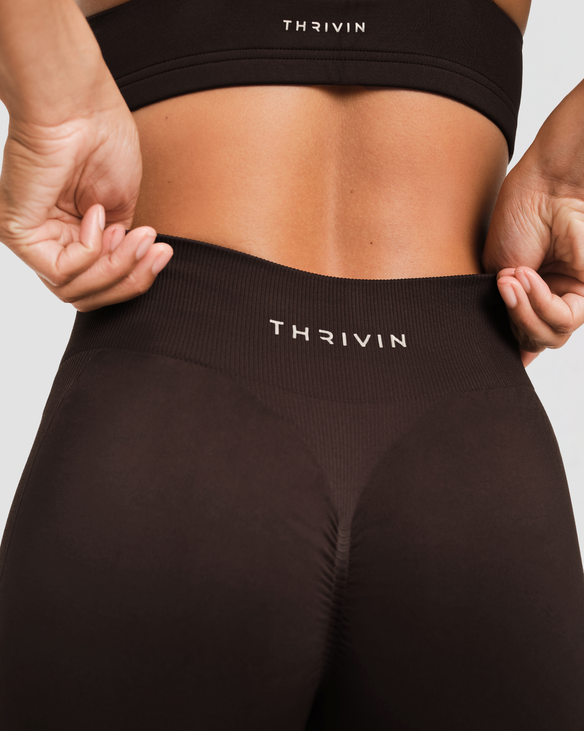 Elevate Sculpting Mid Waist Scrunch Shorts in Coffee Brown, back close-up of center-back scrunch seam and THRIVIN logo