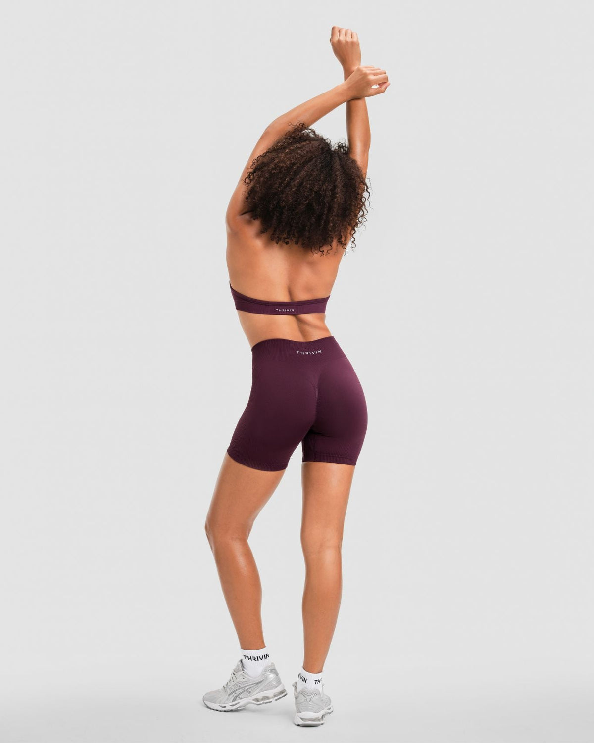 Elevate Sculpting Mid Waist Scrunch Shorter Shorts in Winter Plum Red, full-length back view with Thrivin logo waistband