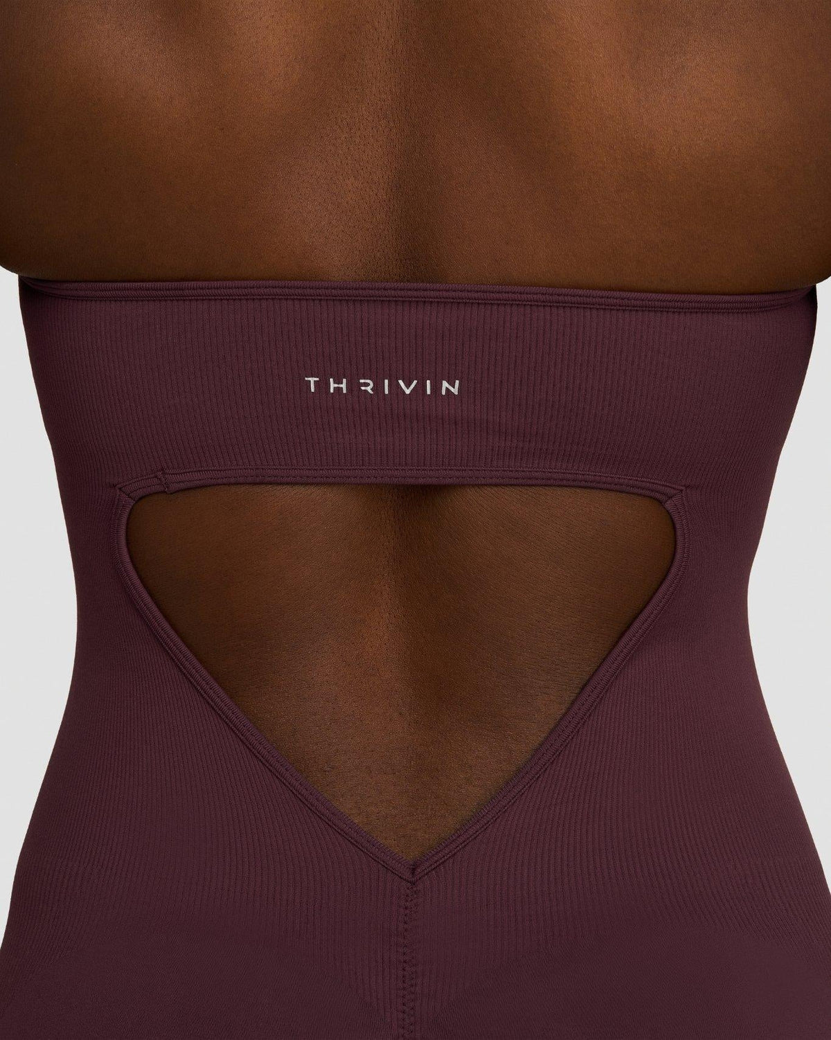 Elevate Sculpting Halterneck All In One in Dark Mauve, back close-up of heart-shaped open back cutout and Thrivin logo